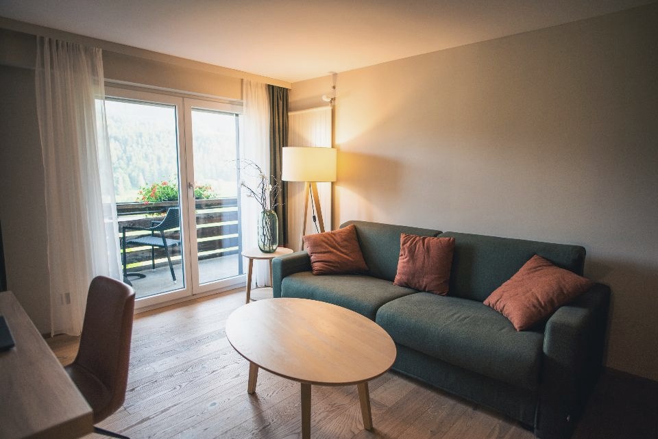 Wohnzimmer mit Sitzgruppe und bodentiefen Terrassentüren zum Garten