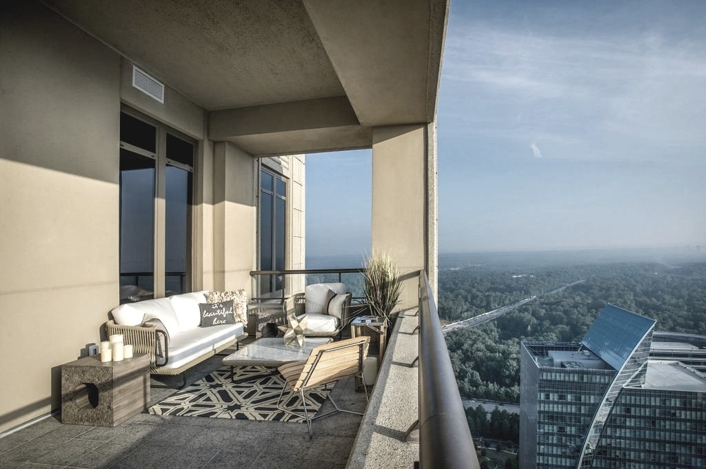 Überdachte Dachterrasse mit Sitzgruppe, Blick über Dächer und Grünflächen der Stadt