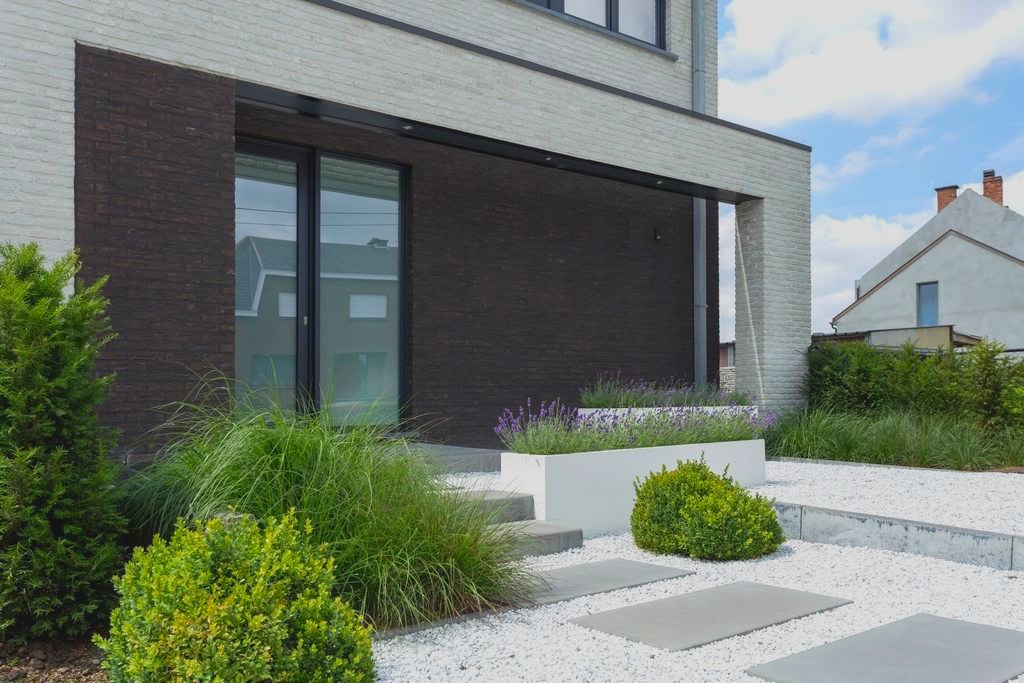 Moderner Neubau mit dunkler Klinkerfassade, bodentiefen Fenstern und angelegtem Vorgarten